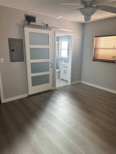 Primary bedroom. Barn door to bathroom and walk-in closet. - 1153 Rue des Rois
