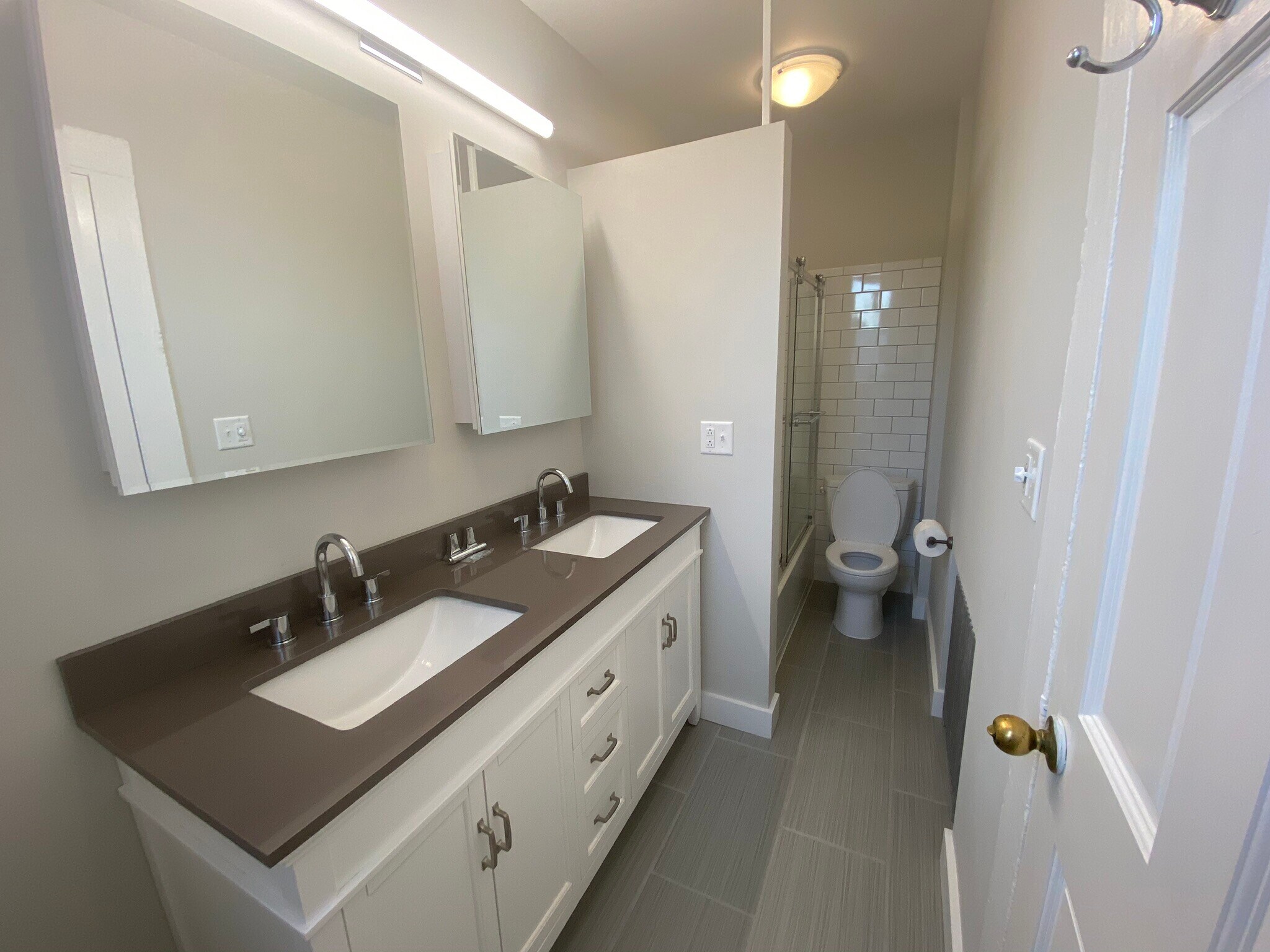 New bathroom features new double vanity, porcelain floors, tub / shower combo, and glass doors - 55 Pearl St