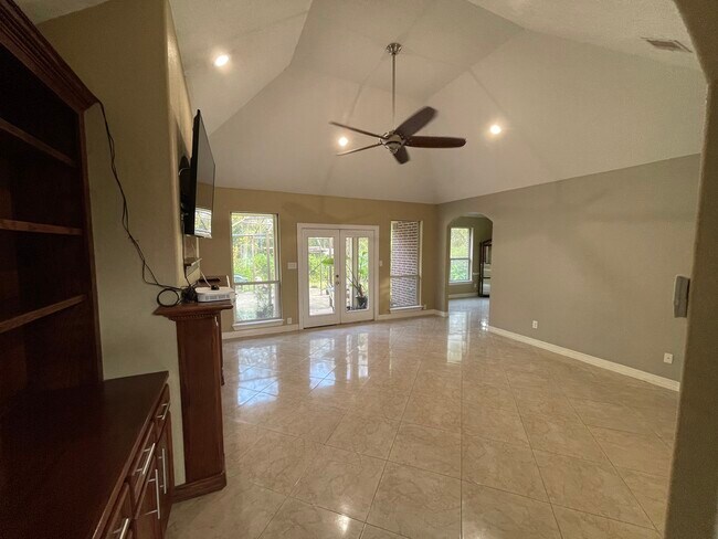 Living room with wet bar, high vaulted ceilings, recess lighting, custom wood cabinets, chimney - 600 River Bend Dr