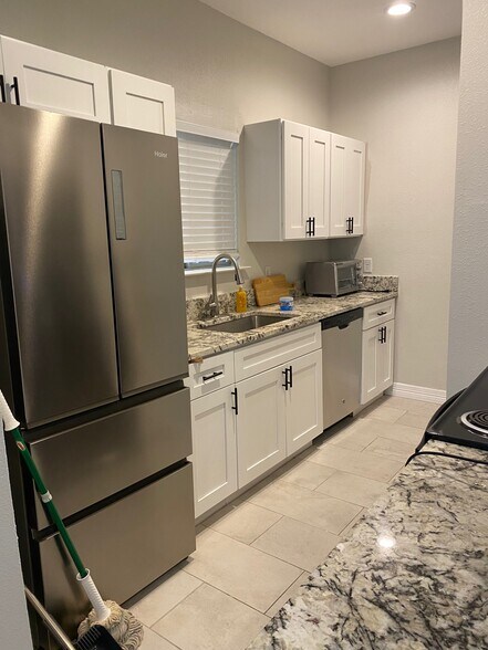 Kitchen view with stainless steel fridge included in rent - 5550 Spring Valley Rd