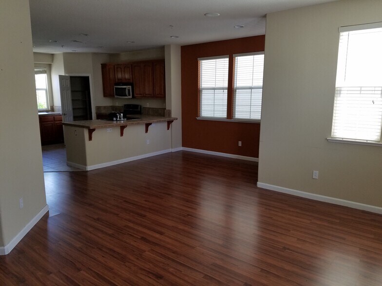 A well lit living room with natural light falling into it from three directions. - 2878 Hilltop Mall Road