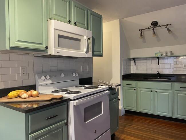 Kitchen with new electric range and granite countertops. - 16 Eames St