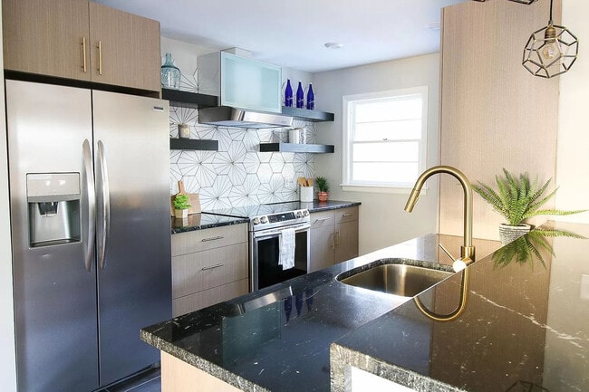 Modern kitchen with tiled backsplash and all stainless steel appliances - 905 Culpepper Ln