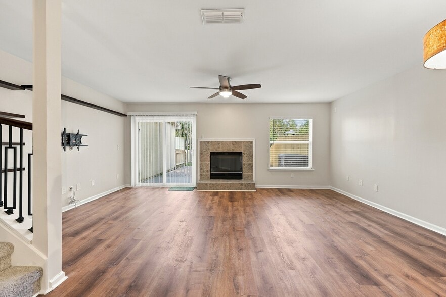 Spacious living room featuring a fireplace and direct access to the private backyard. - 3622 Caroline Vale Blvd