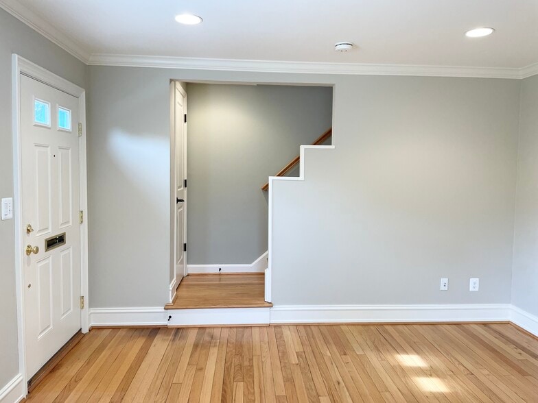 Well lit living room. Coat closet and stairs to upstairs. - 1620 Graefield Rd