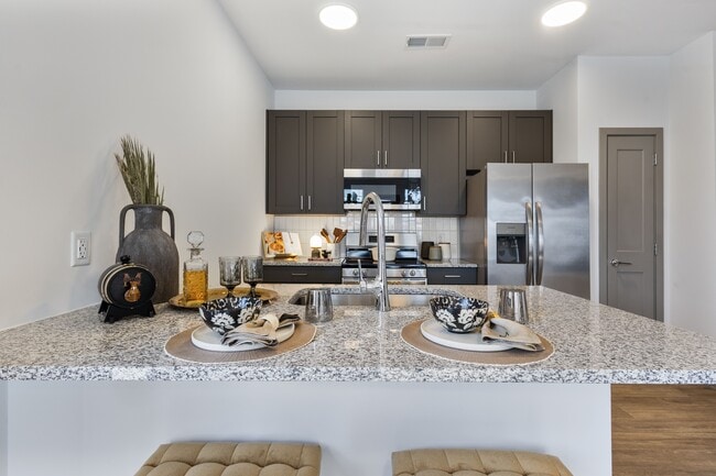 Modern model apartment kitchen with island seating at Montage West Lafayette.