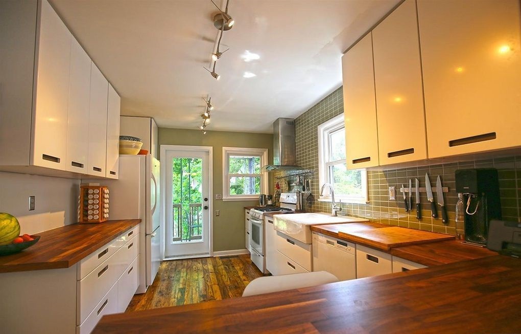 The kitchen has been lovingly updated with Maple countertops, a Breakfast Bar with seating for 4, a white Farm Sink, subway tile backsplash AND soft-close IKEA Cabinets - 903 Highland Rd