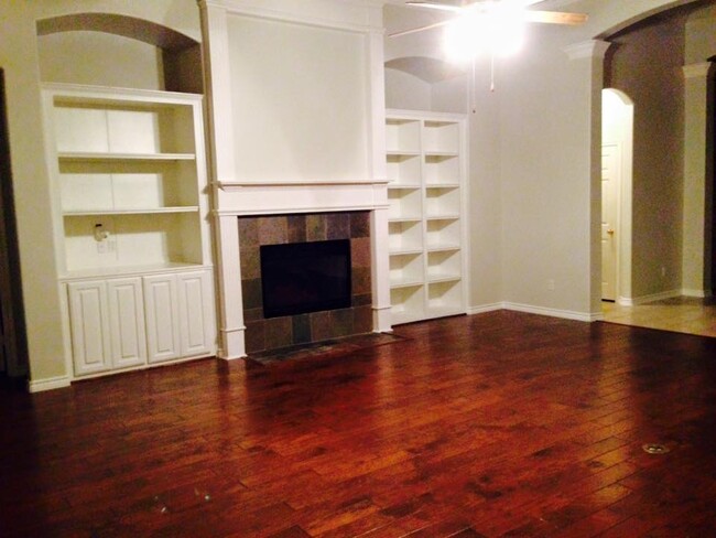 Living room with hardwood floors and built in bookshelves. - 1810 Manchester Way