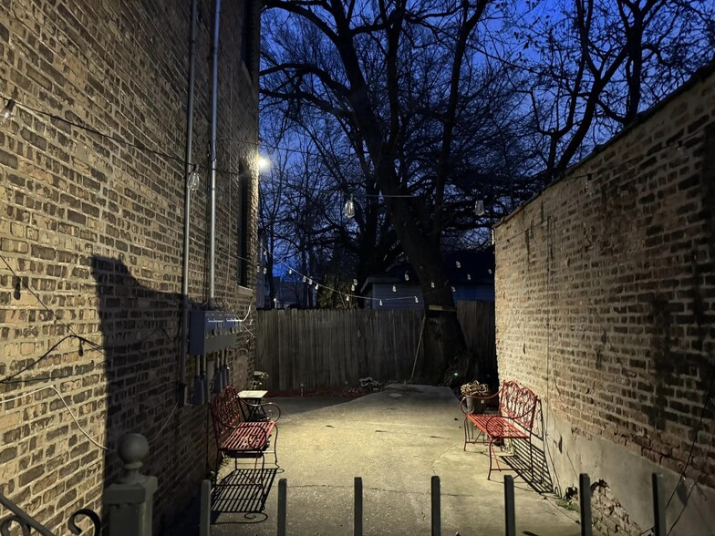 Gated backyard with string lights, benches and firepit - 551 N Lavergne Ave