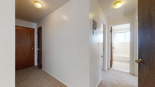Explore this inviting corridor leading to a well-lit bathroom and spacious rooms. - Melody Apartments