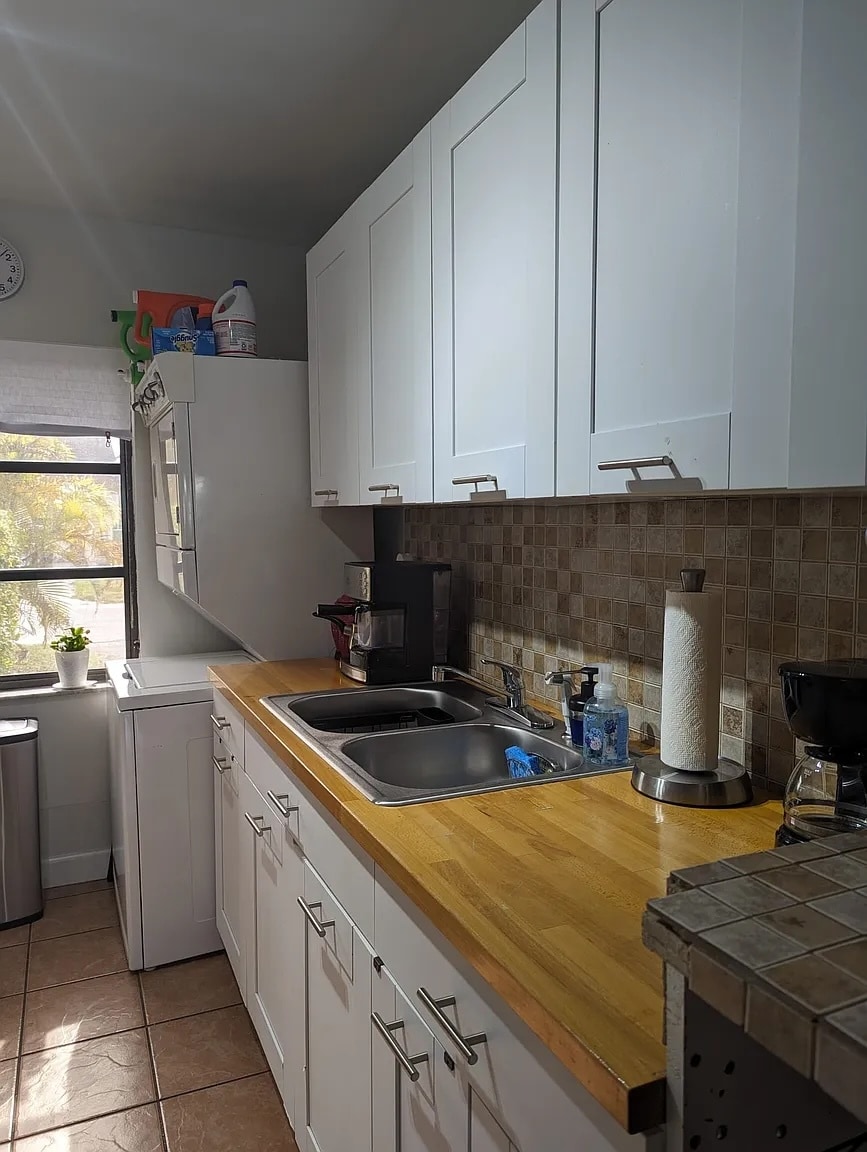 Stainless steel double sink includes garbage disposal. - 13928 SW 52nd Ln