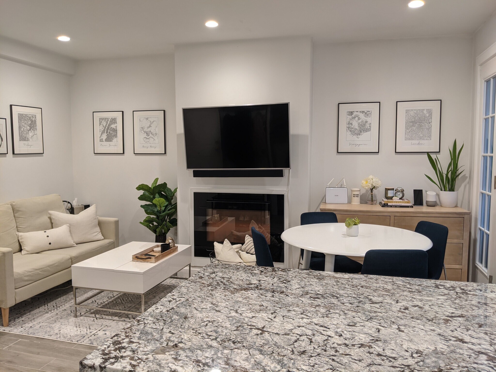 Open living room with electric fireplace and multiple seating areas - 12 Melrose St