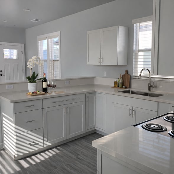 Modern kitchen featuring white shaker cabinetry, quartz countertops, stainless steel appliances. - 262 Soledad St