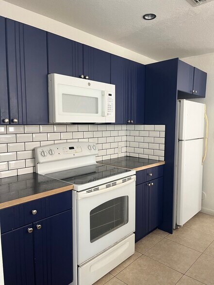 kitchen with microwave, fridge/freezer, stove, oven, dishwasher, cabinets, sink - 812 NW 22nd Pl