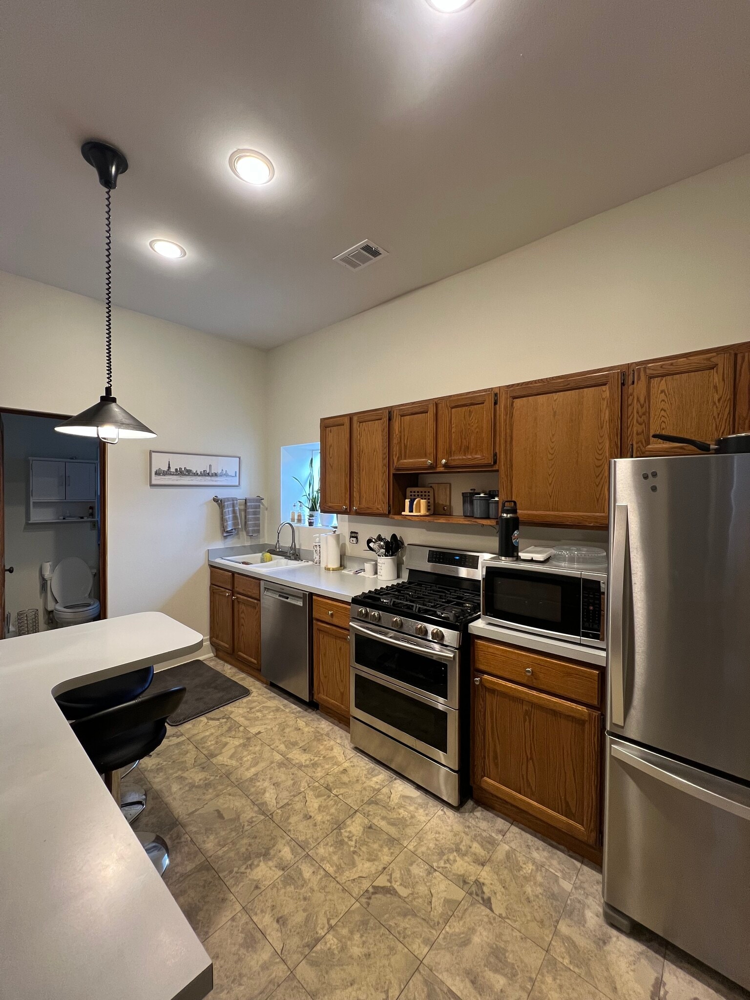 Kitchen with stainless steel appliances and small bar seating for two. Fully furnished with everythi - 938 W Newport Ave