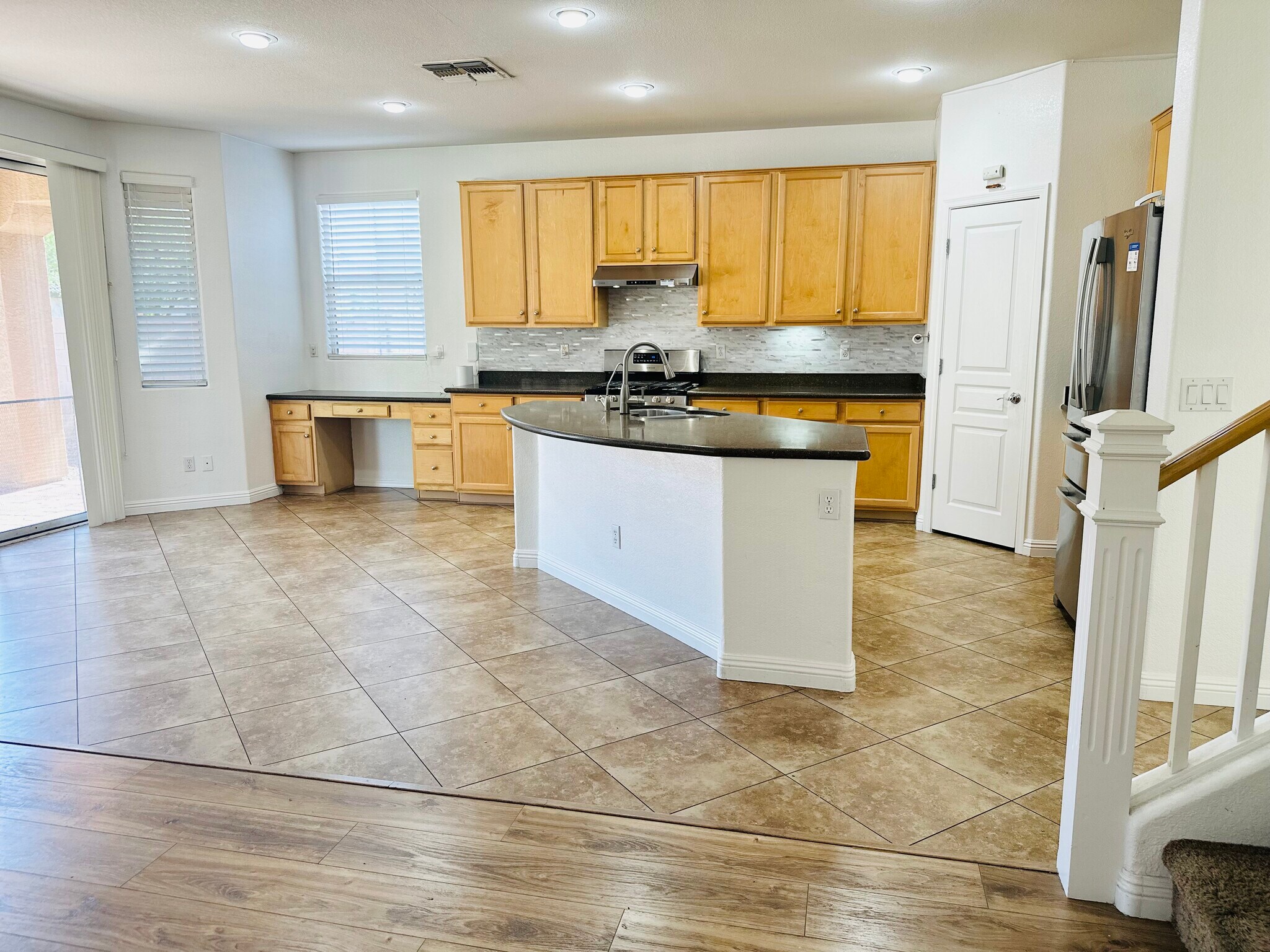 Open kitchen with a granite island and stainless steel appliances. - 1177 W Laredo Ave