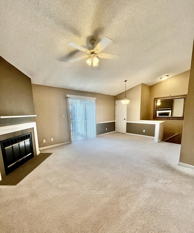 Living/dining room with vaulted ceilings, fireplace and sliding glass doors to front deck - 1458 High School Dr