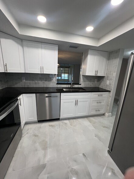 White shaker cabinets, new stainless steel appliances, and granite countertops - 1060 NW 80th Ave