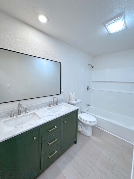 Beautifully remodeled bathroom featuring a tub/shower combo, large mirror, and elegant double quartz - 4570 58th St