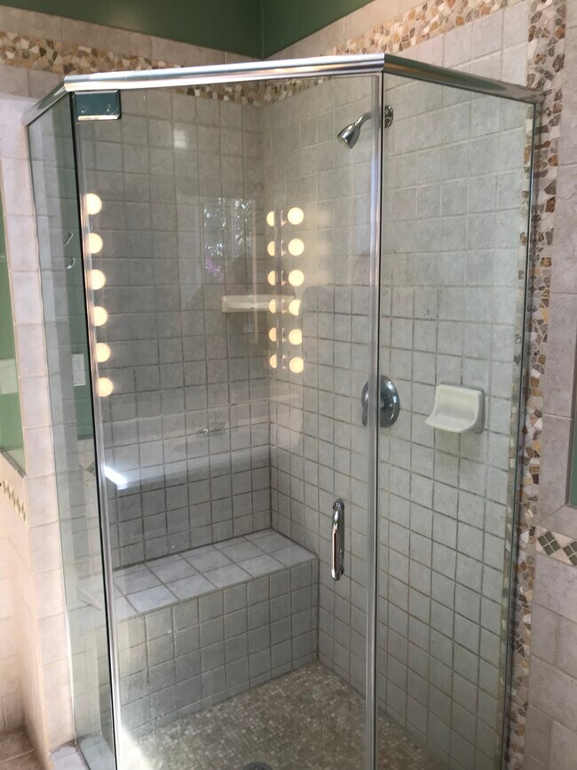 Custom shower stall with marble tile floor, bench and 3/8" glass surround. - 14911 Fonthill Ave