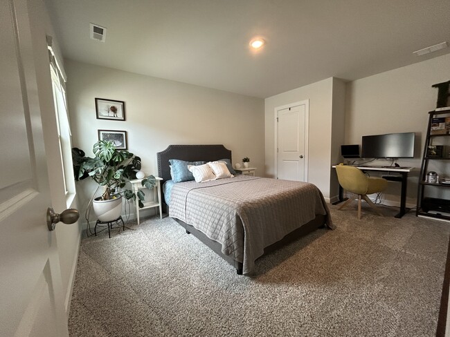 Upstairs bedroom 1, currently set up as a guest room and office. - 4111 Honey Locust Dr