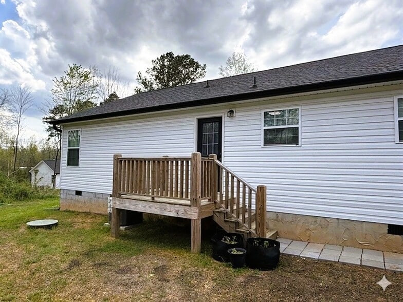 Rear deck with exterior steps for easy backyard access - 111 Buster Ln