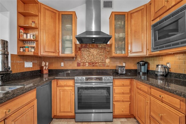 Kitchen boasts granite countertops, high end stainless steel appliances, mosaic insert on tile backs - 1109 NE 3rd St