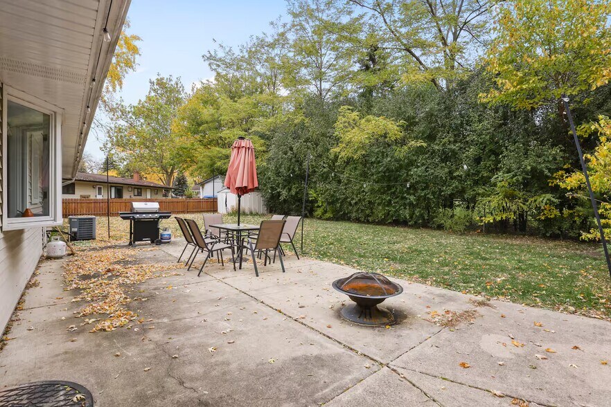 Outdoor patio table set with umbrella, grill and fire pit. Fenced backyard. - 1002 Juniper Ln