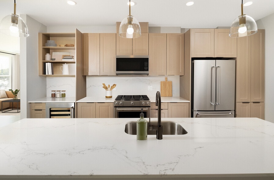 Signature Collection Kitchen with oak shaker cabinetry, marbled white quartz countertop and backsplash, and upgraded stainless steel appliances - Avalon W Squared