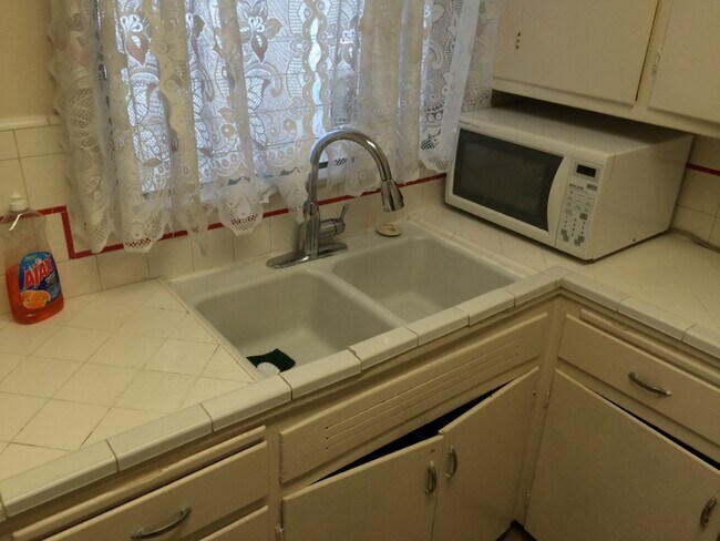 Kitchen sink and counter top showing cabinets below - 5646 Farmdale Ave