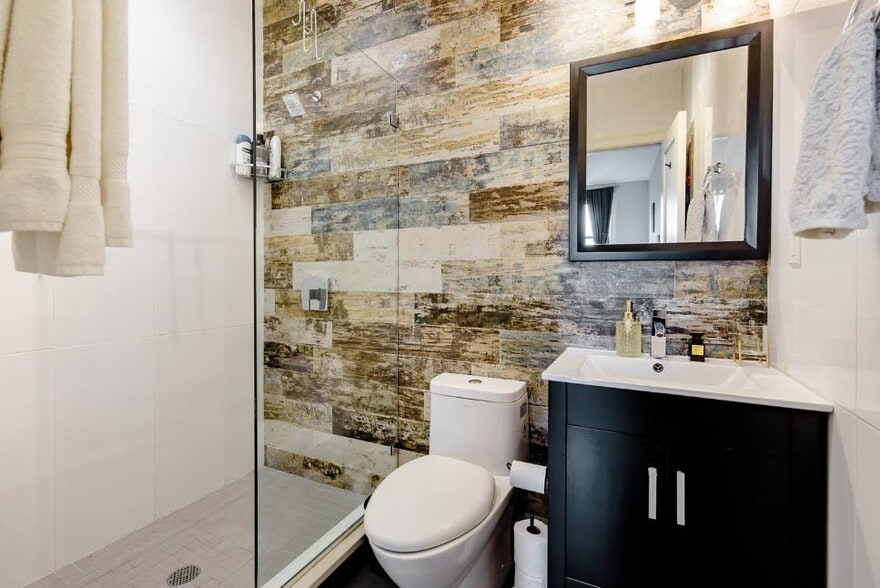 Spa-like en suite bathroom featuring a sleek, contemporary walk-in shower with modern finishes. - 504 Maple St