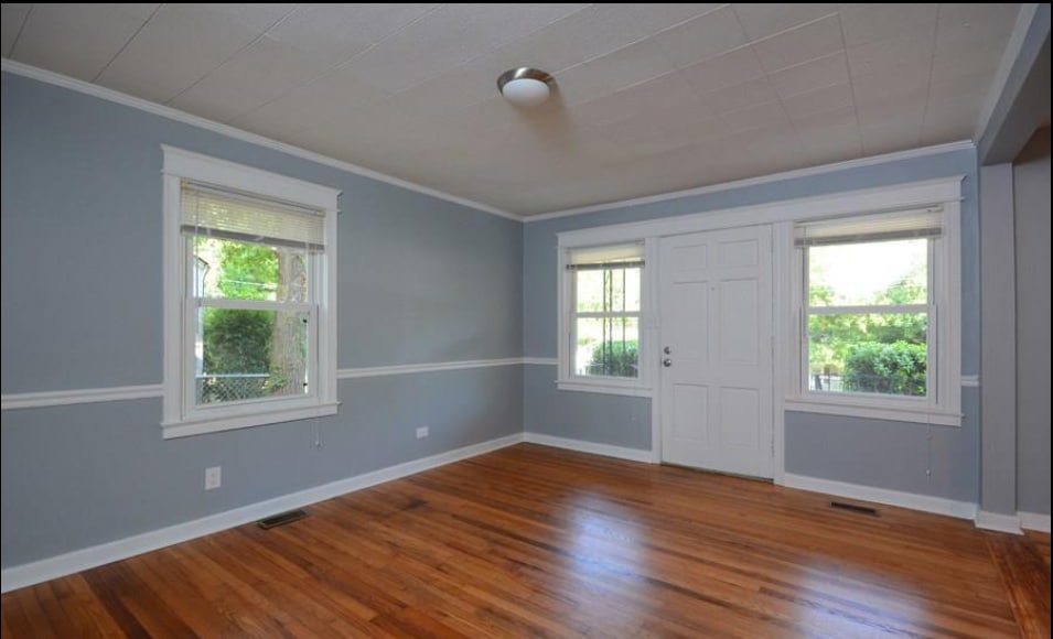 Spacious living area with hardwood floors and natural light. - 1607 Robinhood Rd