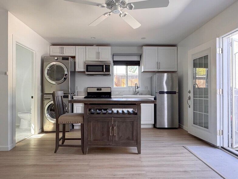 Kitchen area with table seating, and an in-unit stackable LG brand washer/dryer. - 3541 Helms Ave