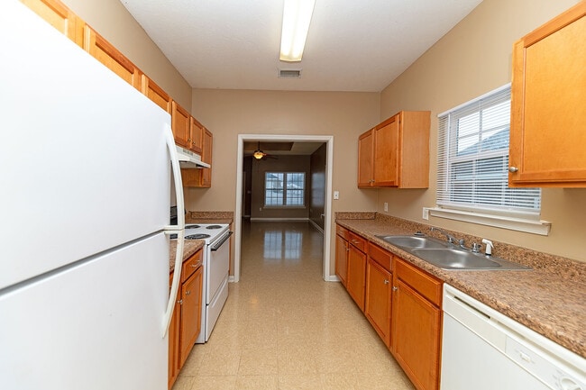Kitchen with white appliances, wooden cabinetry, and generous counterspace - Lakeview Subdivision