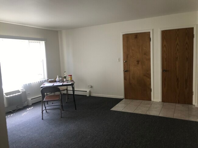 Living room with coat closet and front door entrance. - 8616 47th St