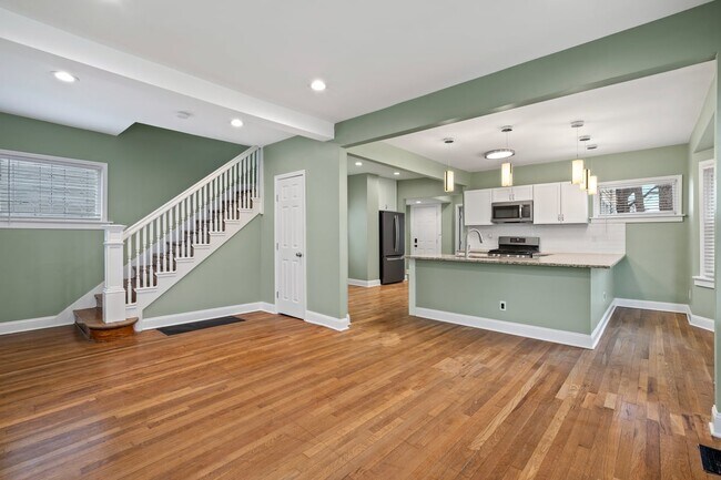 Open concept living room and kitchen area with vaulted ceilings and wrap around counter height bar - 4517 Tracy Ave