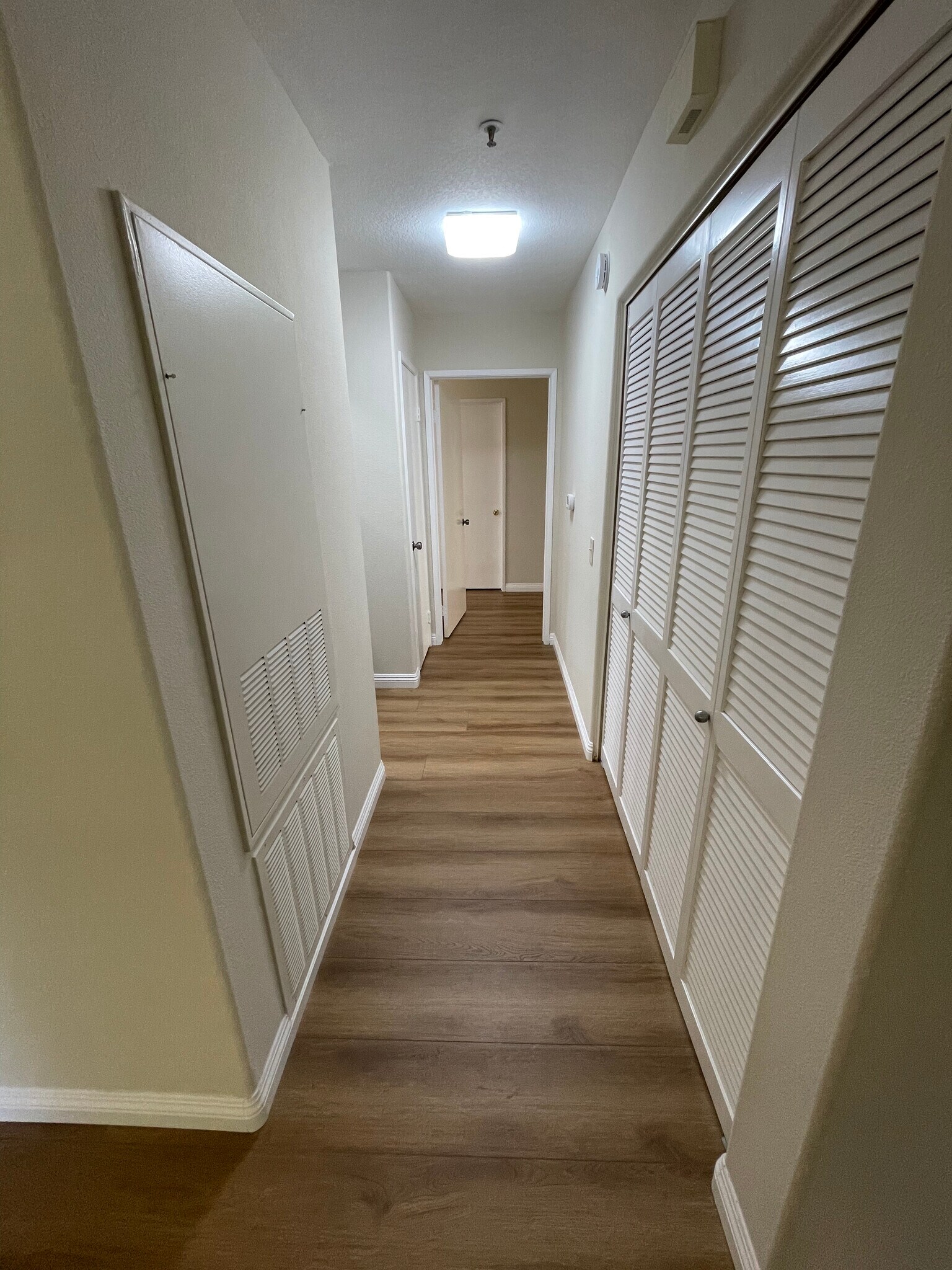 hallway with AC access on left of view and washer/dryer cabinet on the right - 2960 Champion Way