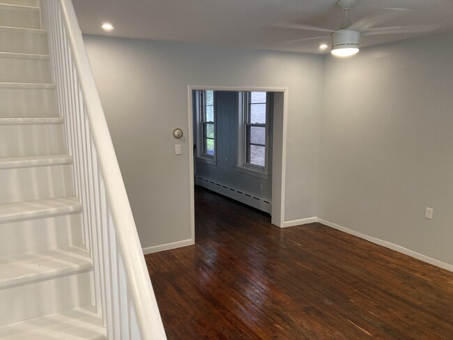 The living room features original, refinished hard wood floors, an open staircase, and a lovely fron - 2621 E Somerset St