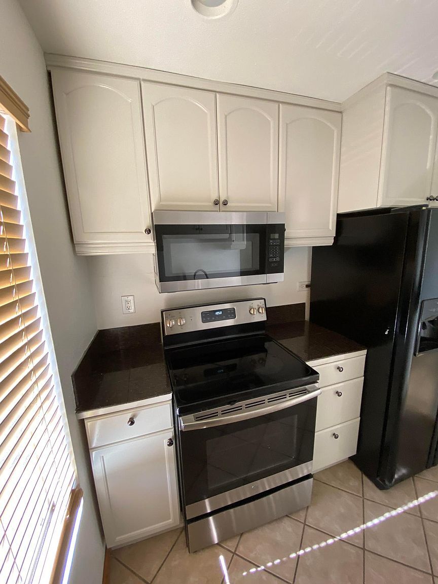 Kitchen with refrigerator, range, microwave, and dishwasher - 8305 Summertime Ln