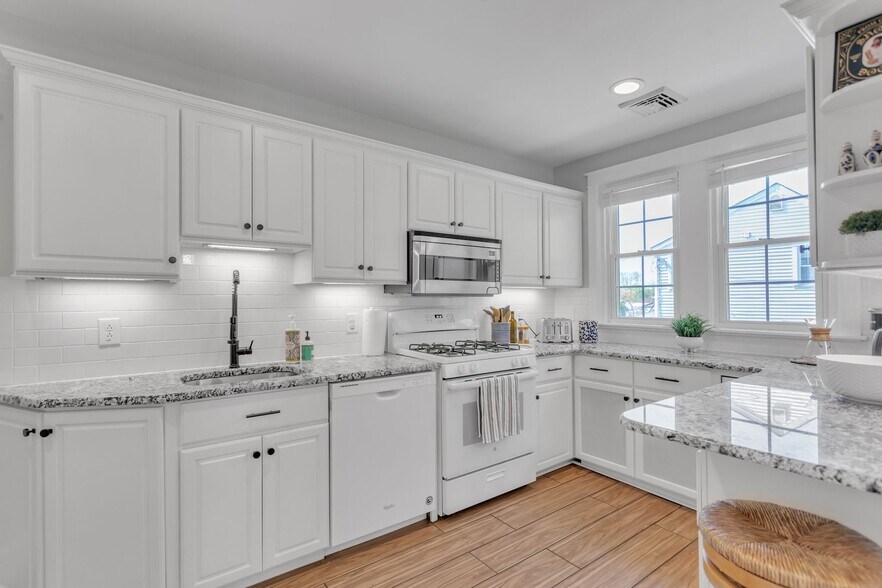 Bright Kitchen with entrance from DR. Gas Stove, granite counters, under counter lighting. Pantry. - 2314 Bryn Mawr Ave