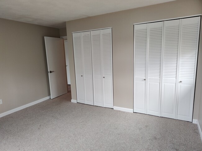 Master bedroom with new carpet, paint, closet doors, and baseboard - 9 Kenmar Dr