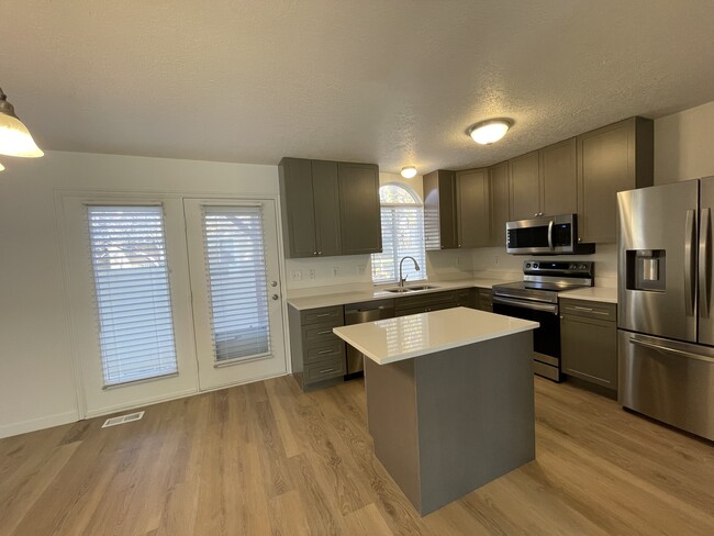 Kitchen with island and dining area - 9485 S Fairway View Dr