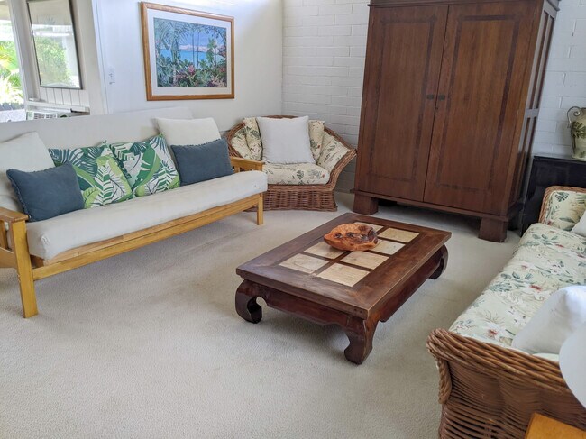 Living room with a queen futon and teak furniture. Relax and watch your fav streaming TV. - 426 Ilimano St