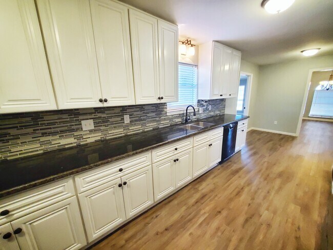 Dishwasher, stone countertops, soft close cabinets, and glass tile backsplash complete this kitchen. - 37438 Meadowview Dr