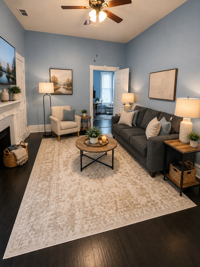Bright furnished living room with historic fireplace and Smart TV - 319 W 33rd St