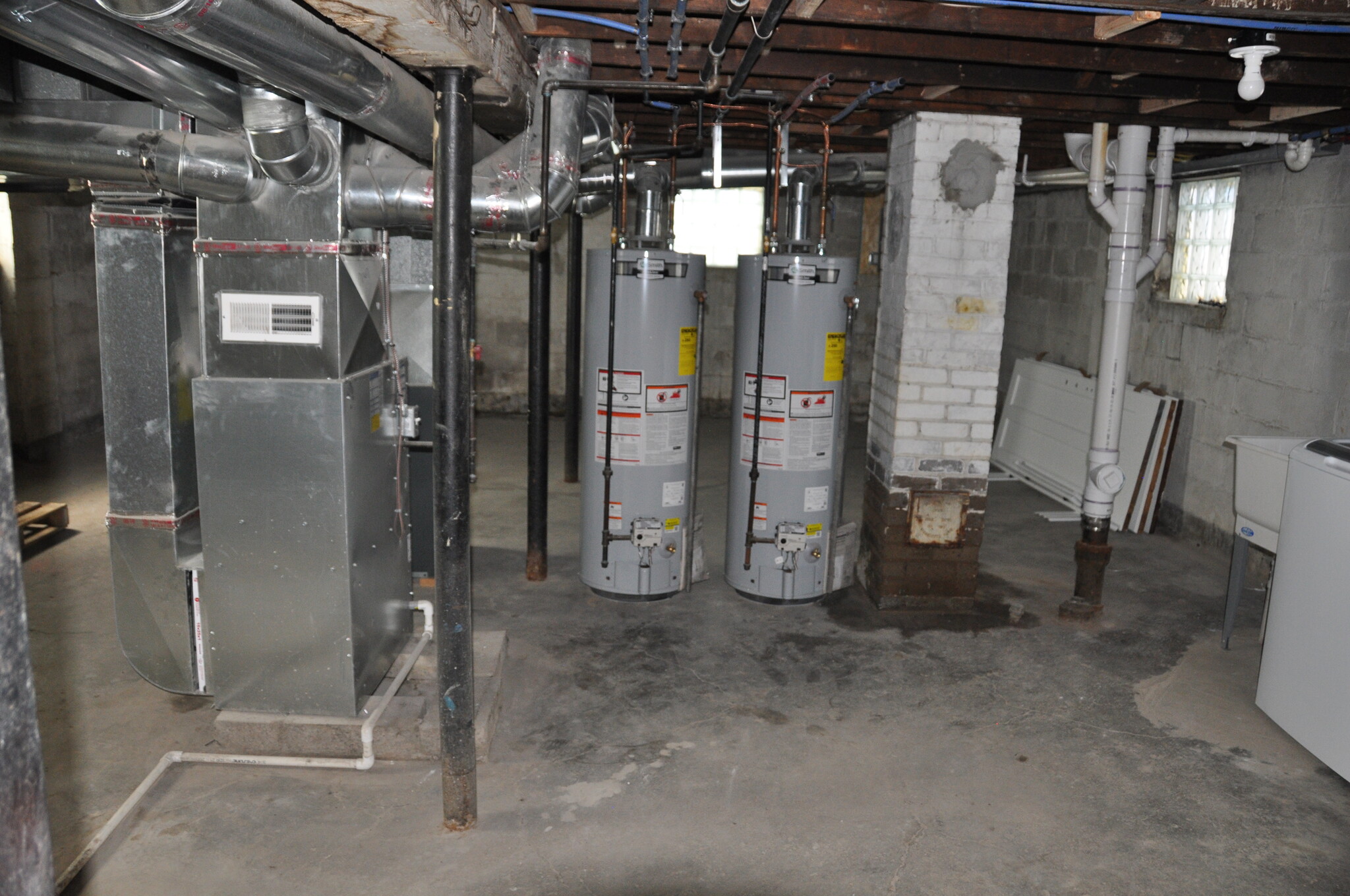 Basement - separate furnaces, water heaters, gas & electric. Storage areas behind HVAC. - 526 Academy St