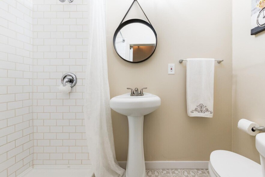 Hall bathroom opens with barn door, and has large stall shower with pedestal sink. - 665 Cathedral Dr