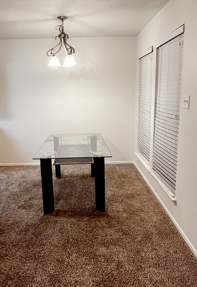 Cozy, elegant dining room with soft lighting. The room features two large windows and chandelier. - 4917 Jamesway Rd