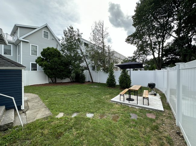 Professionally landscaped backyard with patio. Shared. White vinyl fence throughout. - 58 S Waverly St