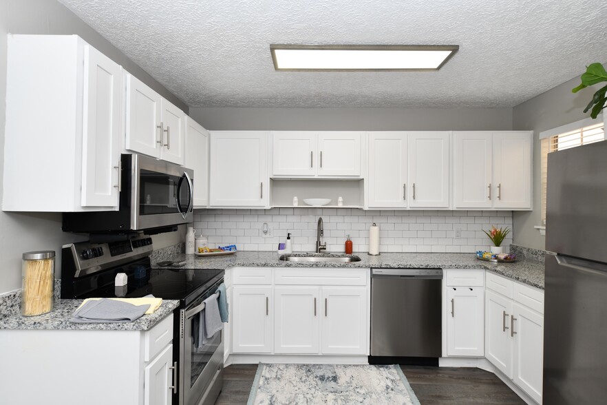 Kitchen area with ample cabinetry & counter space - The Huntley Apartment Homes